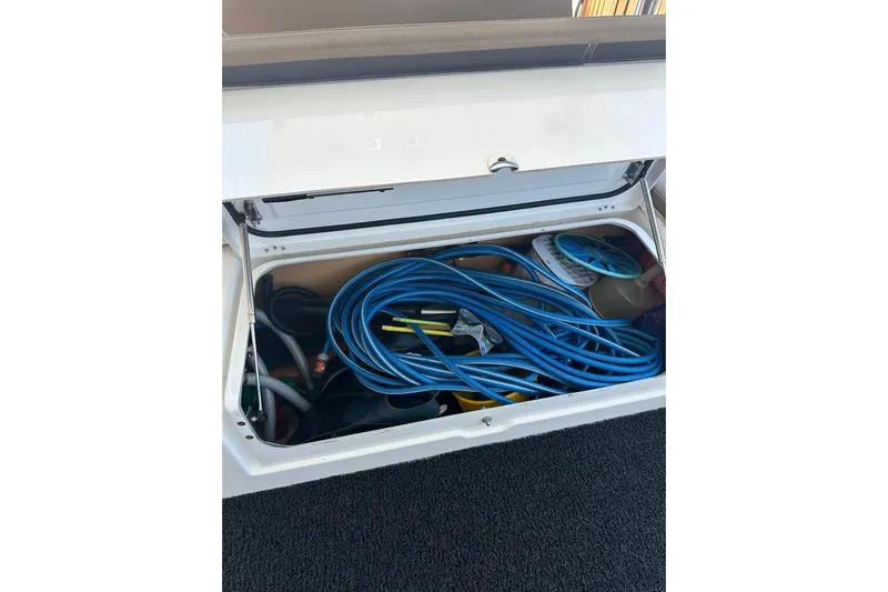  Yacht Photos Pics Storage compartment of 2012 Lagoon 450 yacht with blue hoses and equipment.