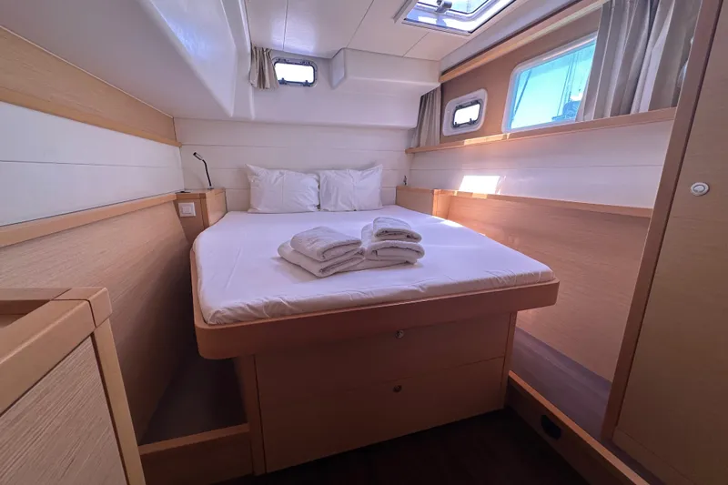  Yacht Photos Pics Luxurious cabin interior of 2012 Lagoon 450 catamaran with cozy bed and natural light.