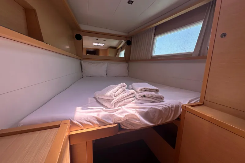  Yacht Photos Pics Cozy cabin interior of 2012 Lagoon 450 yacht with bed and window view.