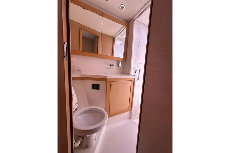  Yacht Photos Pics Bathroom interior of 2012 Lagoon 450 yacht, featuring modern fixtures and wooden cabinetry.