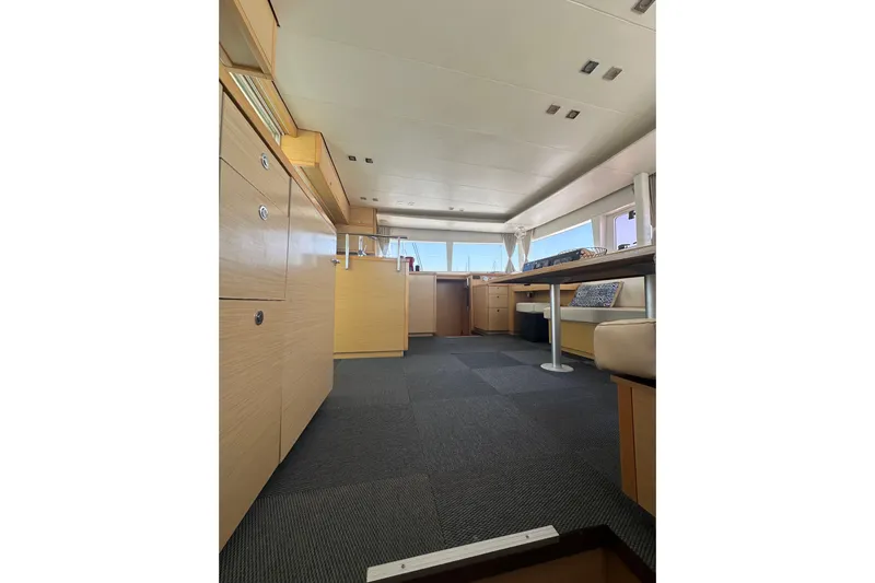 Yacht Photos Pics Interior of 2012 Lagoon 450 catamaran, featuring modern wood cabinetry and spacious seating area.
