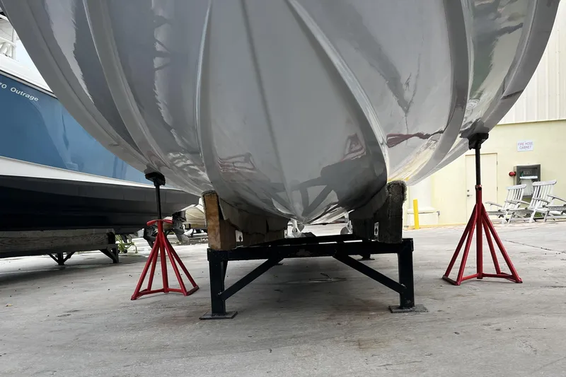 300 - 112 Brokerage Kevin Yacht Photos Pics 2023 Robalo R302 Center Console boat hull on stands in a storage area.