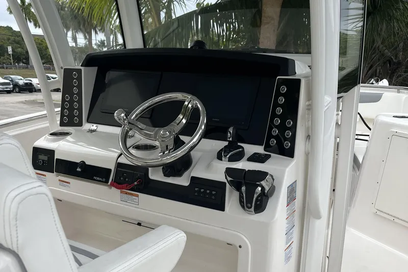 300 - 112 Brokerage Kevin Yacht Photos Pics 2023 Robalo R302 Center Console boat dashboard with steering wheel and controls.