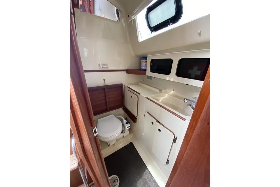 1990 Hunter 27 sailboat bathroom with toilet, sink, and storage cabinets.