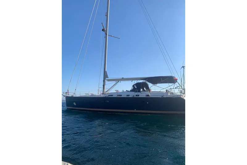  Yacht Photos Pics 2004 Beneteau Oceanis Clipper 523 sailboat on calm blue water under clear sky.