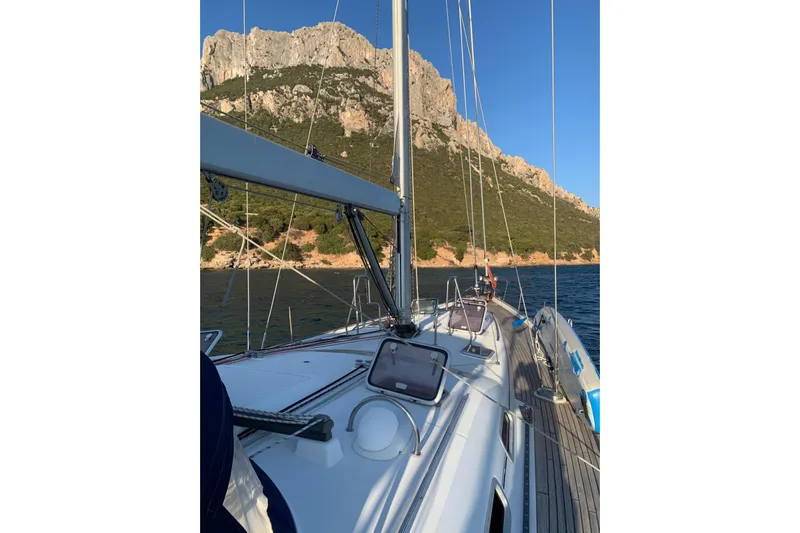  Yacht Photos Pics Sailing on a 2004 Beneteau Oceanis Clipper 523 near rocky coastline.