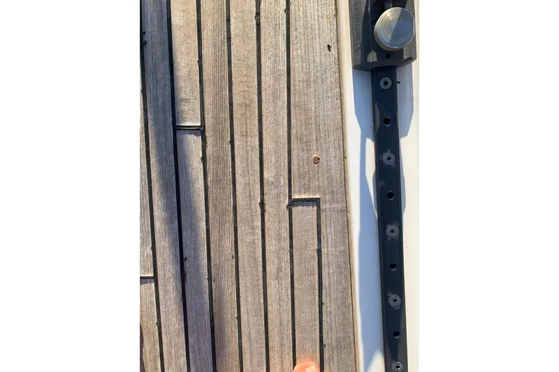  Yacht Photos Pics Close-up of 2004 Beneteau Oceanis Clipper 523 deck with wooden planks and metal fitting.