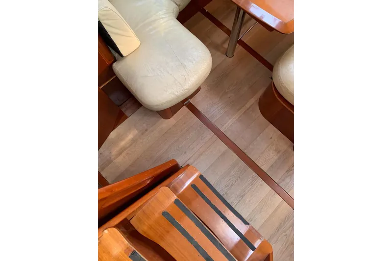  Yacht Photos Pics Interior of 2004 Beneteau Oceanis Clipper 523, featuring wooden flooring and cushioned seating.