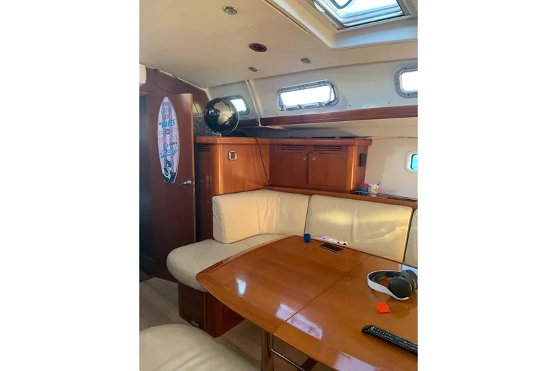  Yacht Photos Pics Interior of 2004 Beneteau Oceanis Clipper 523 yacht with wooden table and seating.
