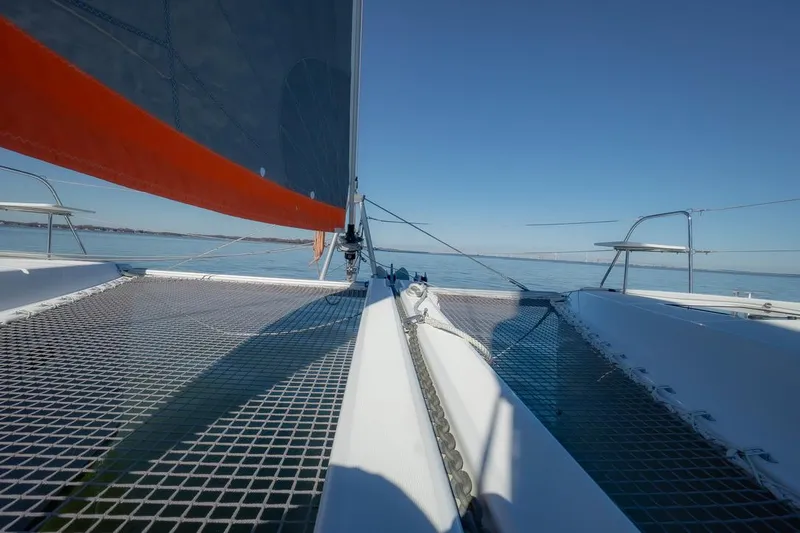 Eli X Yacht Photos Pics Sailing catamaran Excess 11, 2023 model, on calm waters under clear blue sky.