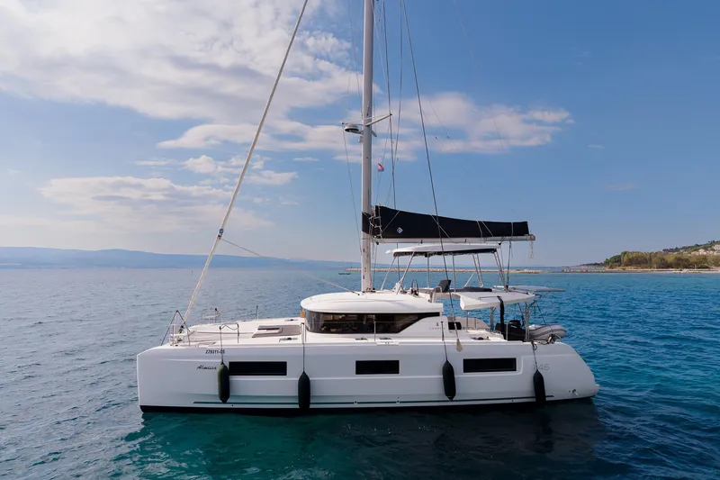 Almissa Yacht Photos Pics 2023 Lagoon 46 catamaran sailing on calm blue waters under a clear sky.
