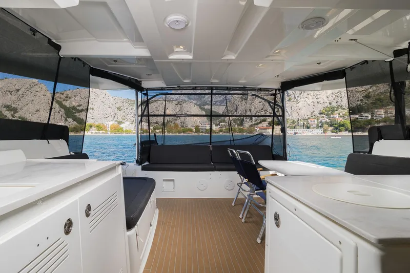 Almissa Yacht Photos Pics Interior view of 2023 Lagoon 46 catamaran with scenic coastal backdrop.