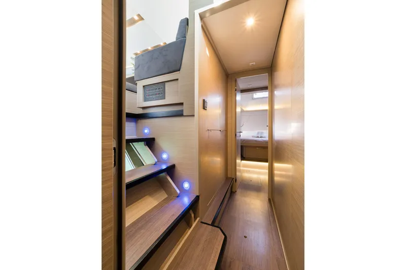 Almissa Yacht Photos Pics Interior of 2023 Lagoon 46 yacht, featuring modern wooden staircase and hallway lighting.