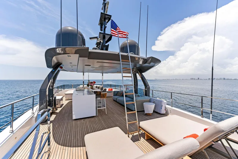 Double Up Yacht Photos Pics Luxurious 2024 Custom Line Navetta 33 yacht deck with seating, ocean view, and American flag.