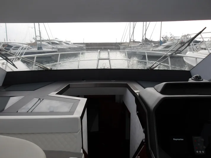  Yacht Photos Pics Interior view of 2023 Galeon 500 Fly yacht, showcasing helm and marina backdrop.