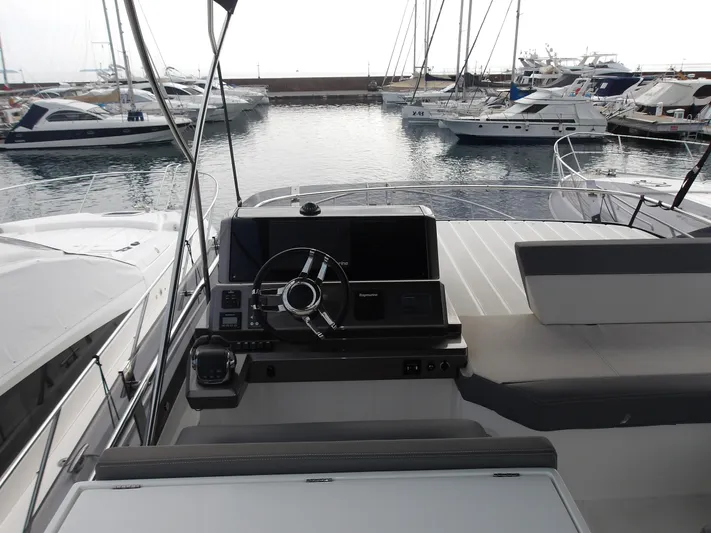  Yacht Photos Pics 2023 Galeon 500 Fly yacht helm with marina view, featuring modern steering and navigation controls.