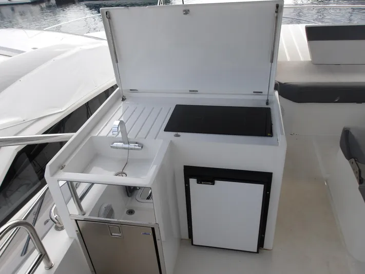  Yacht Photos Pics Outdoor kitchenette on 2023 Galeon 500 Fly yacht with sink, grill, and mini fridge.
