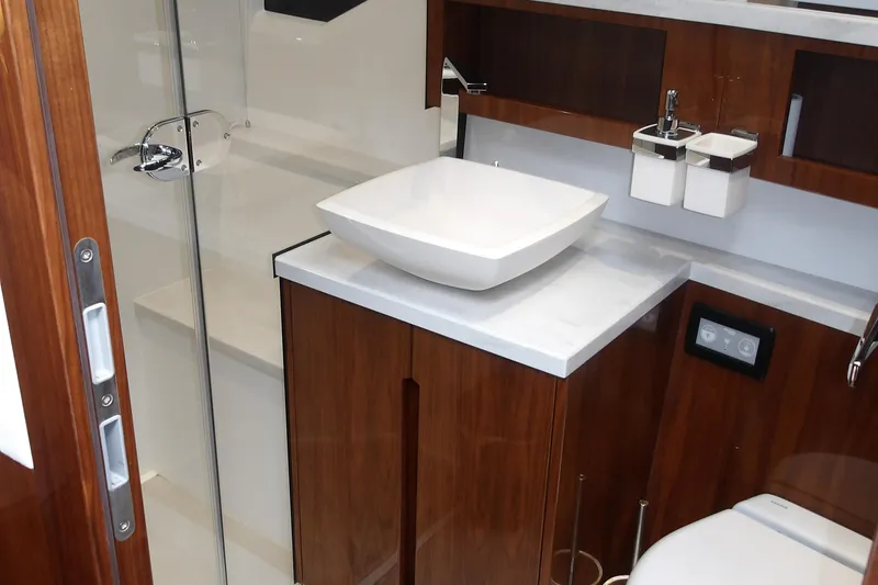  Yacht Photos Pics Luxurious bathroom interior of 2023 Galeon 500 Fly yacht with modern sink and wooden cabinetry.