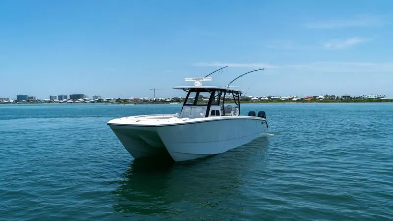  Yacht Photos Pics 2024 Invincible 40' Catamaran on calm waters with a clear blue sky.