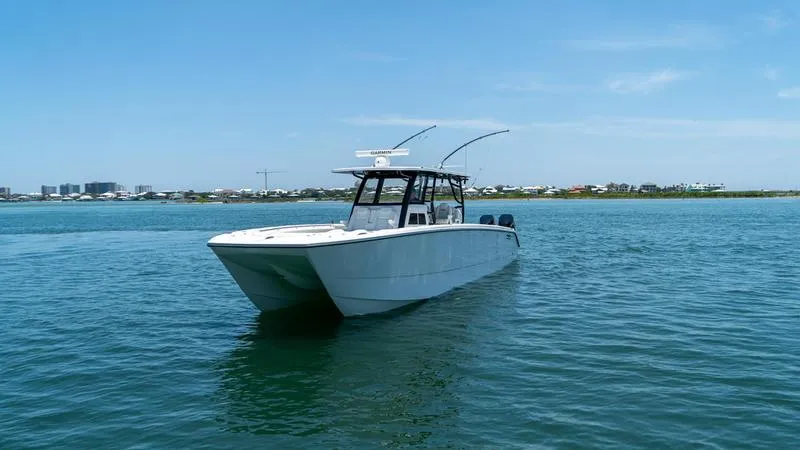  Yacht Photos Pics 2024 Invincible 40' Catamaran on calm waters with a clear blue sky.