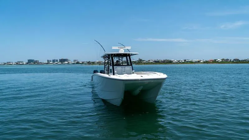  Yacht Photos Pics 2024 Invincible 40' Catamaran on calm waters with cityscape background.
