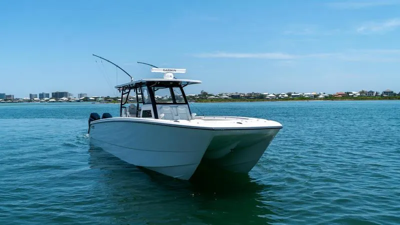 Yacht Photos Pics 2024 Invincible 40' Catamaran on calm waters with coastal background.