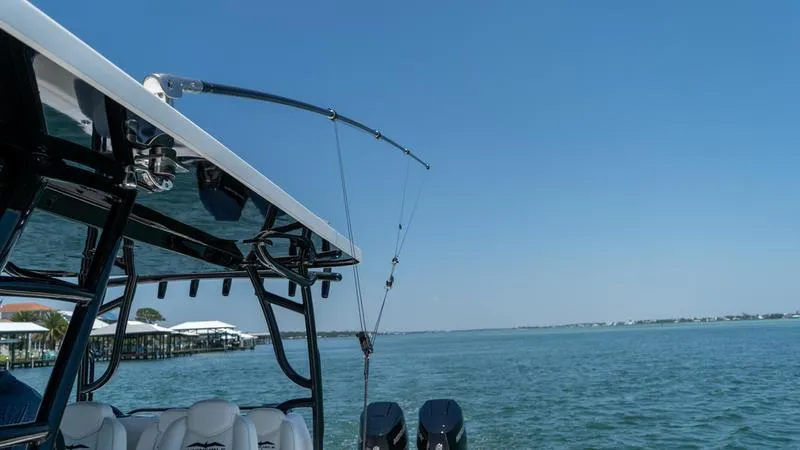  Yacht Photos Pics 2024 Invincible 40' Catamaran on water with fishing rods and outboard motors.