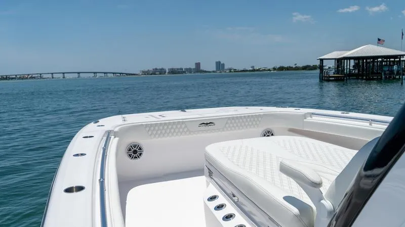  Yacht Photos Pics 2024 Invincible 40' Catamaran on calm waters with city skyline in the background.