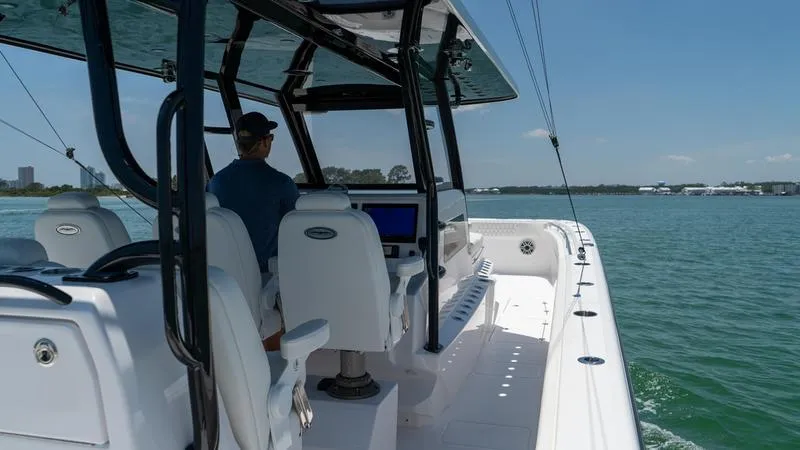  Yacht Photos Pics 2024 Invincible 40' Catamaran cruising on a sunny day with a person at the helm.