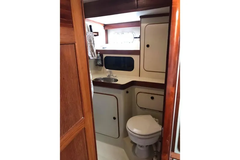 Pacific High Yacht Photos Pics 1983 Stuart Marine 62 Custom Ketch bathroom with wooden accents and compact design.