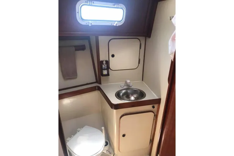 Pacific High Yacht Photos Pics Compact bathroom in 1983 Stuart Marine 62 Custom Ketch, featuring sink and toilet.