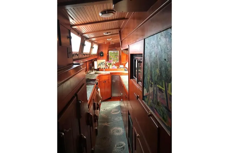 Pacific High Yacht Photos Pics Interior of 1983 Stuart Marine 62 Custom Ketch, featuring wood paneling and nautical decor.