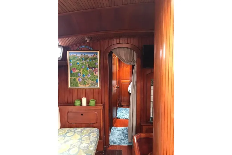 Pacific High Yacht Photos Pics Interior of 1983 Stuart Marine 62 Custom Ketch with wood paneling and colorful artwork.