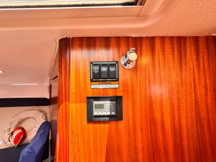Sassea Yacht Photos Pics 2014 Pursuit OS 385 Offshore interior with control panel on wooden wall.