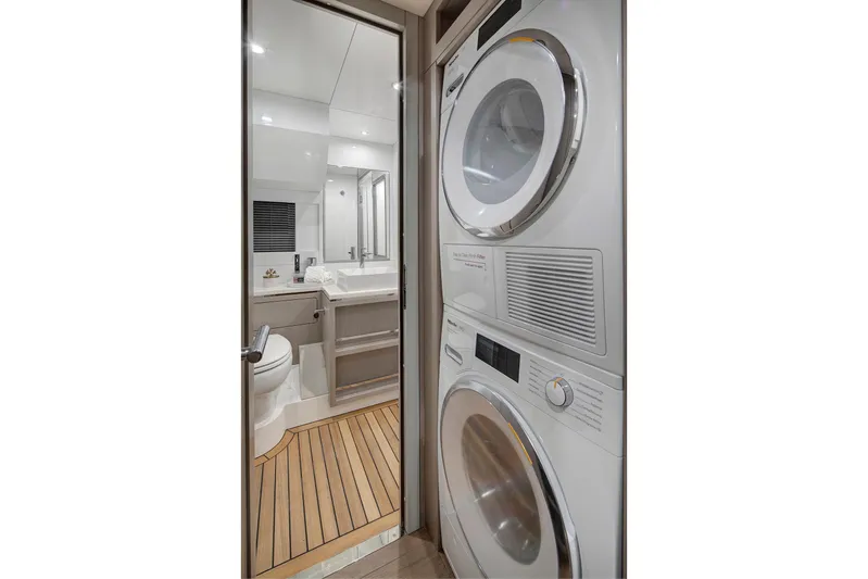  Yacht Photos Pics Laundry area and bathroom in 2027 Sirena 68 yacht, featuring modern appliances and sleek design.