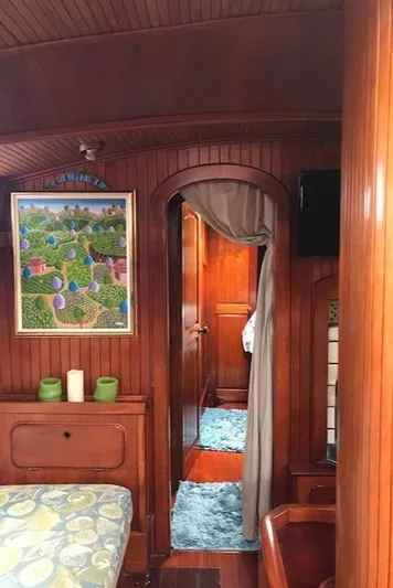 Pacific High Yacht Photos Pics Interior of 1983 Stuart Marine 62 Custom Ketch with wood paneling and colorful artwork.