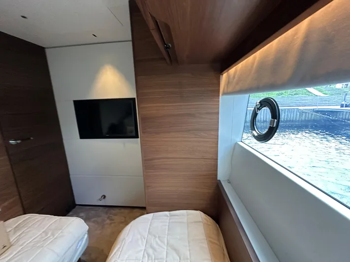  Yacht Photos Pics Luxurious interior of 2022 Princess Y72 yacht with twin beds and a scenic window view.