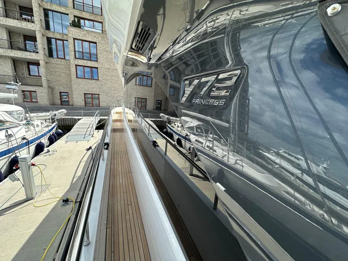  Yacht Photos Pics 2022 Princess Y72 yacht docked, showcasing sleek design and reflective exterior.