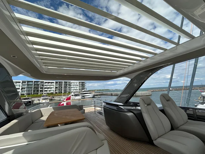 Yacht Photos Pics Luxurious 2022 Princess Y72 yacht interior with modern seating and open roof, docked at marina.