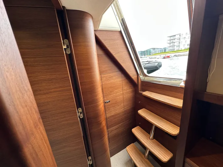  Yacht Photos Pics Interior of 2022 Princess Y72 yacht with wooden stairs and window view.