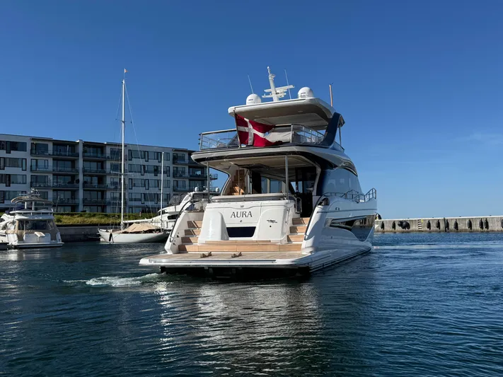  Yacht Photos Pics Luxurious 2022 Princess Y72 yacht cruising in a marina under clear blue skies.