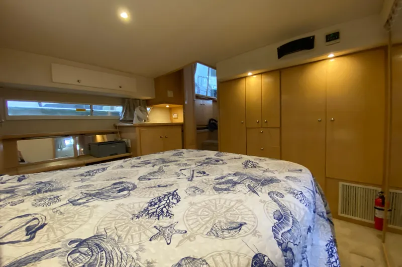 Irish Hurricane Yacht Photos Pics 1998 Carver 445 Aft Cabin Motor Yacht bedroom with nautical-themed bedding and wooden cabinetry.