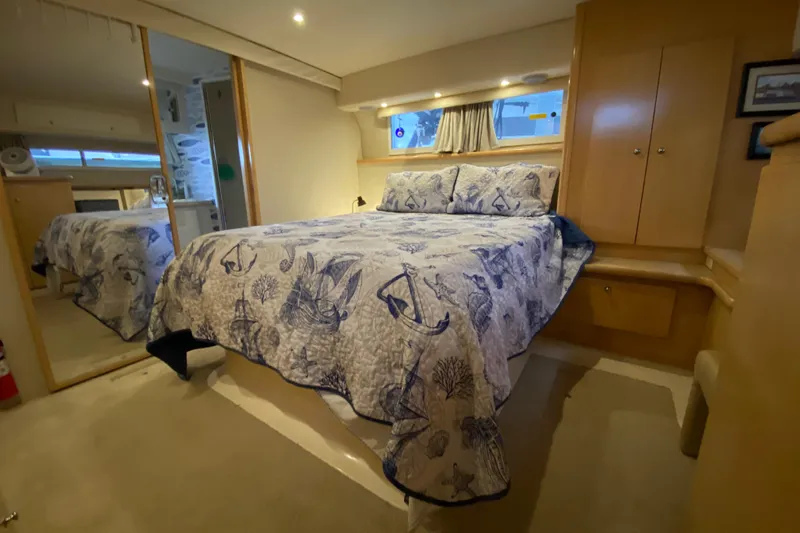 Irish Hurricane Yacht Photos Pics Luxurious 1998 Carver 445 Aft Cabin Motor Yacht bedroom with nautical-themed bedding.