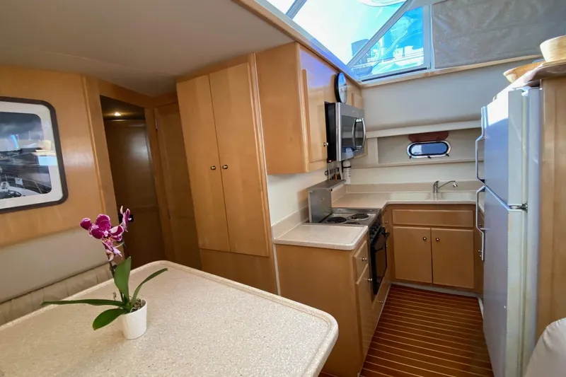Irish Hurricane Yacht Photos Pics 1998 Carver 445 Aft Cabin Motor Yacht interior with kitchen and dining area.