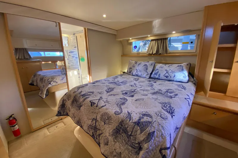 Irish Hurricane Yacht Photos Pics Luxurious 1998 Carver 445 Aft Cabin Motor Yacht bedroom with nautical-themed bedding.