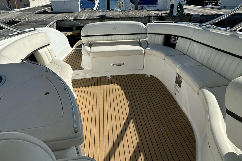  Yacht Photos Pics 2013 Cobalt 336 boat interior with white seating and wooden deck at a marina.