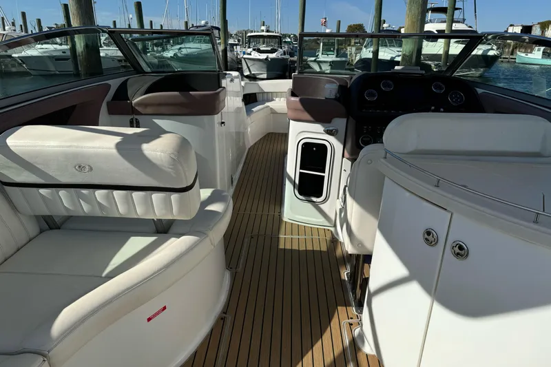  Yacht Photos Pics 2013 Cobalt 336 boat interior with white seating and wooden flooring at a marina.