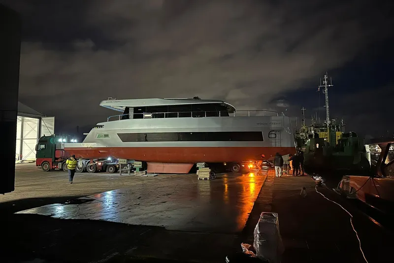 New Moon 60 Power Yacht Photos Pics 2025 Moon 60 Power yacht at night, dockside with workers and equipment.