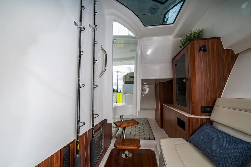  Yacht Photos Pics Manufacturer Provided Image: Interior of 2018 Pursuit DC 365 Dual Console boat with wooden accents and fishing rods.