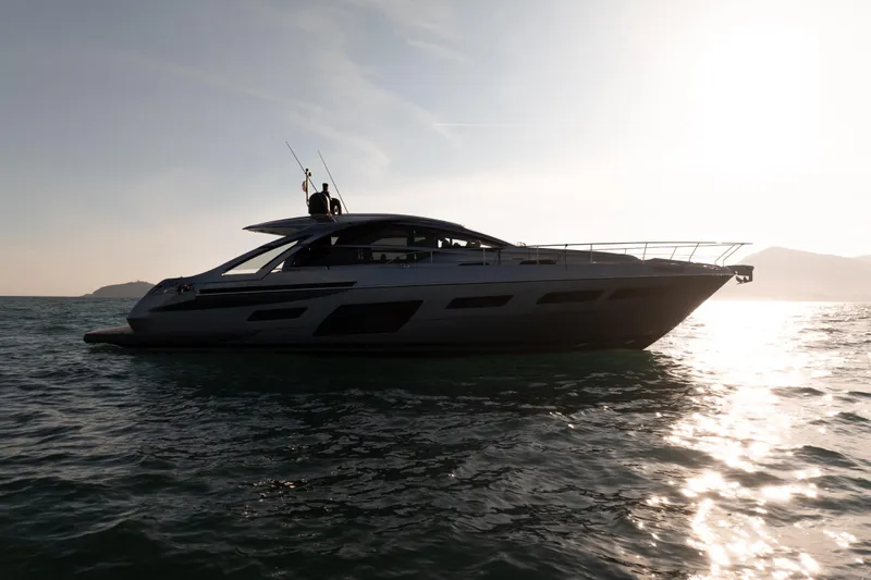 M/y "ghep" Yacht Photos Pics 2022 Pershing 7X yacht silhouetted against sunset on open water.